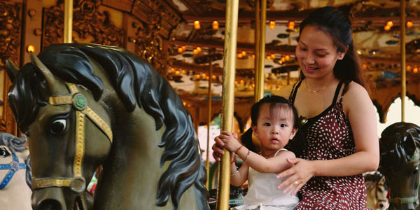 Lady and her daughter on fairground horse